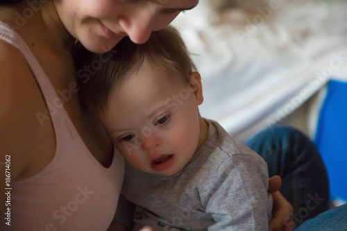 Portrait of cute baby boy with Down syndrome with hih mother