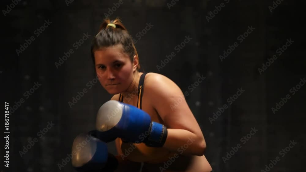 Young woman fighter martial arts training punches with hands on boxing gloves Young woman fighter martial arts training punches with hands on boxing gloves