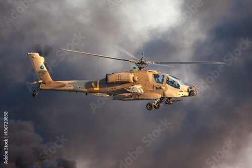 AH-64 Apache attack helicopter fly above Hatzerim Air Force base near Beersheba, Israel in front of black smoke