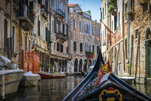 Canals and historic buildings of Venice, Italy, from gondola. Narrow canals, old houses, reflection on water on a summer day in  Venice, Italy.
