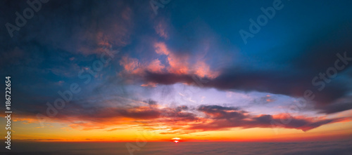 Panoramic aerial view of flying between the cloud at sunset