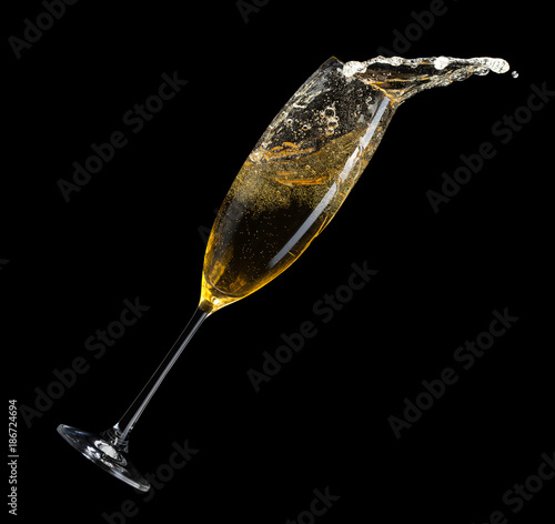 champagne splash from glass on a black background © Iurii Kachkovskyi