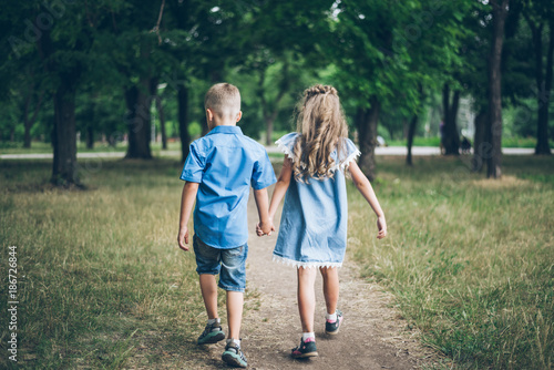 A little boy and girl walking together and holding each other hands