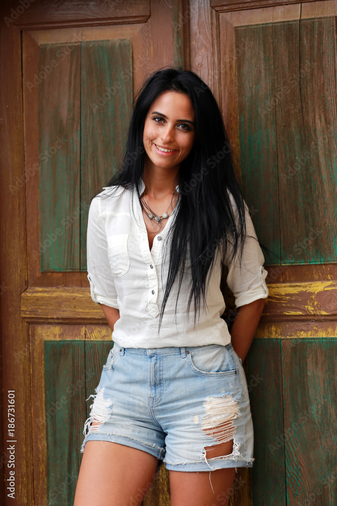 Attractive young woman next to a wooden door Attractive young woman next to a wooden door