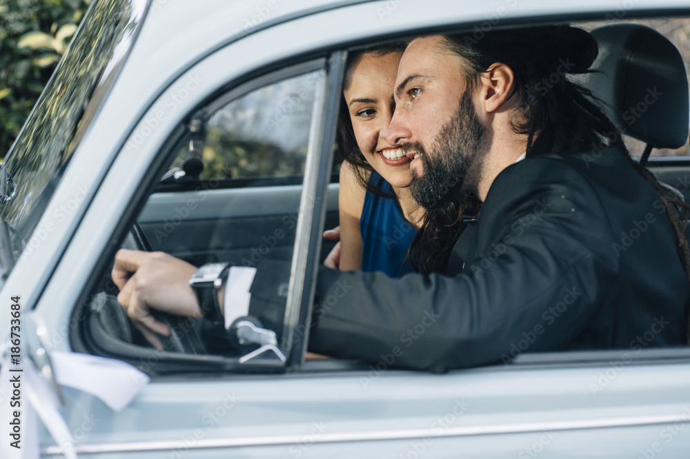 A young couple with a retro car