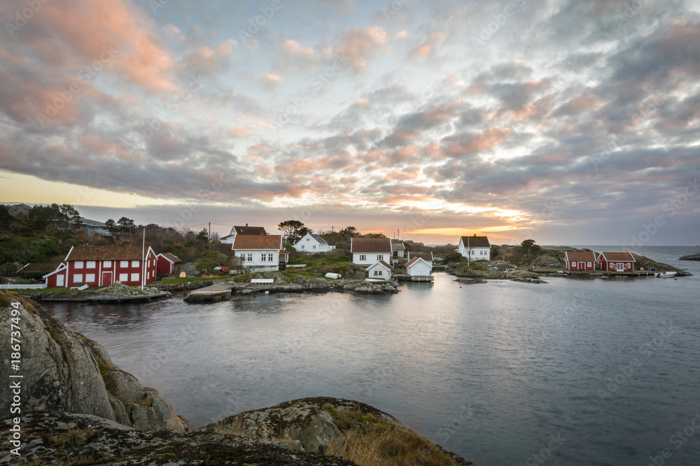Lillesand, Norway - November 7, 2017: Ulvoysund, ocean and old houses on the Ytre Ulvoya in evening light.
