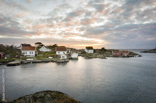 Lillesand, Norway - November 7, 2017: Ulvoysund, ocean and old houses on the Ytre Ulvoya in evening light.