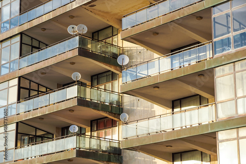 Facade of the reseidential building with windows and balconies and satelite antennas