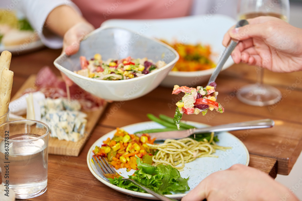 people eating salad at table with food people eating salad at table with food