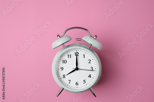 vintage alarm clock on solid pastel pink color background