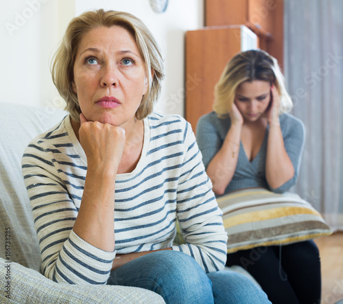 Upset young woman and senior mother having bad argue indoor