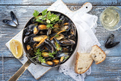Traditional barbecue Italian blue mussel in white wine as top view in a casserole
