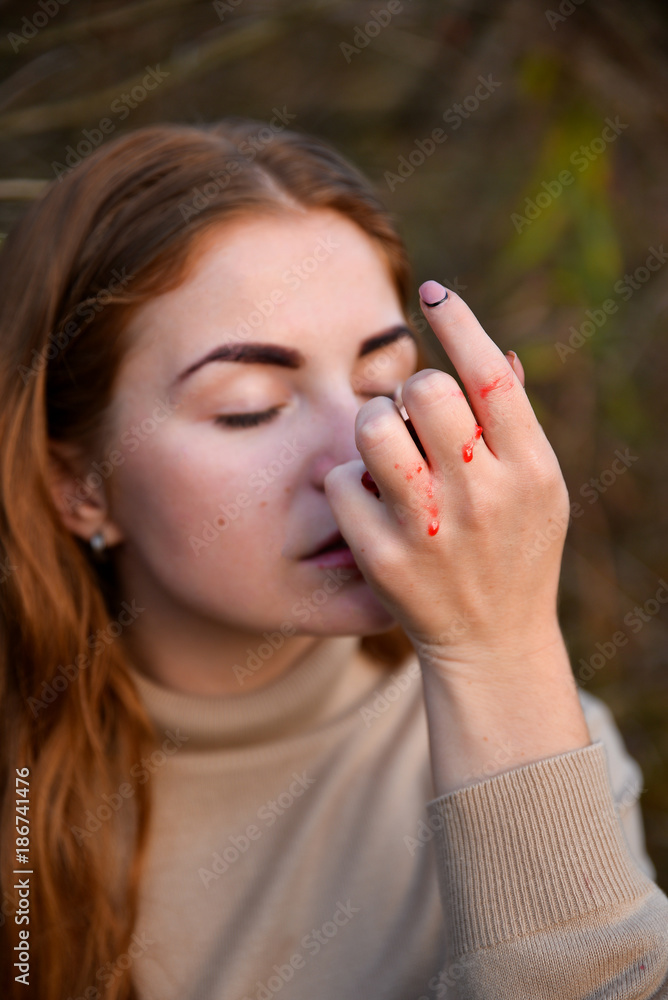 Portrait of beautiful red haired girl posing, walking in autumn forest among yellow grass. Woman with long hair in beige blouse eating red berries from hand. Portrait of beautiful red haired girl posing, walking in autumn forest among yellow grass. Woman with long hair in beige blouse eating red berries from hand.