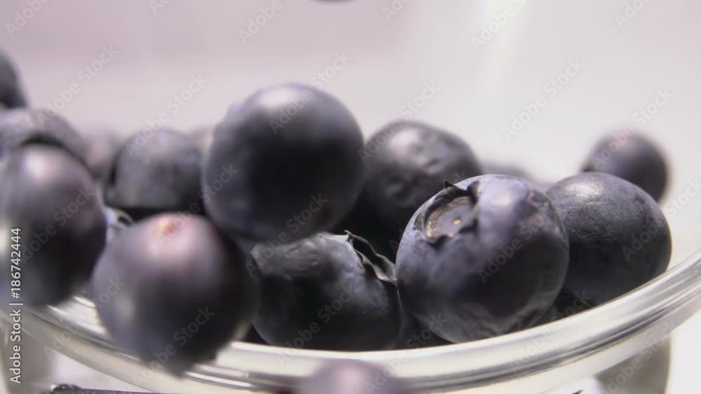 Close-up of blueberries spilling out of a glass bowl Close-up of blueberries spilling out of a glass bowl