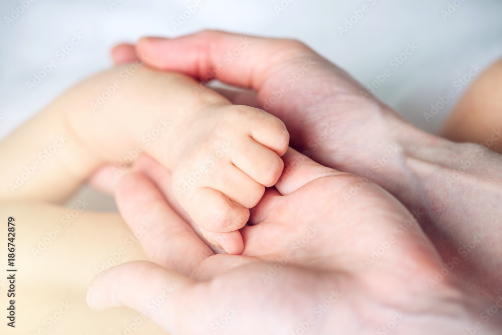 Mother holding the hand of a baby. Concept of empathy, trust, care and tenderness of motherhood Mother holding the hand of a baby. Concept of empathy, trust, care and tenderness of motherhood