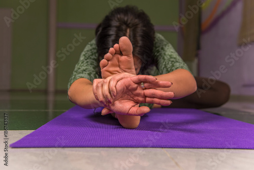 Female practices yoga lesson in a studio