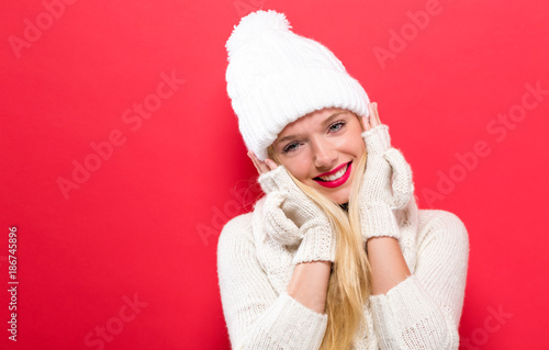 Happy young woman in winter clothes on a solid background