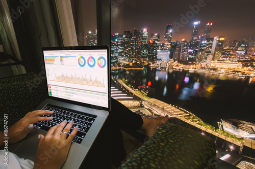 Canvas Print Woman freelancer is working using laptop computer in home office at night