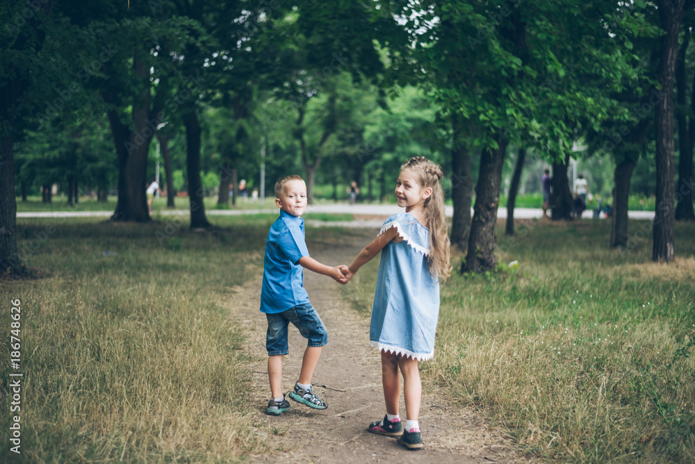A little boy and girl walking together and holding each other hands