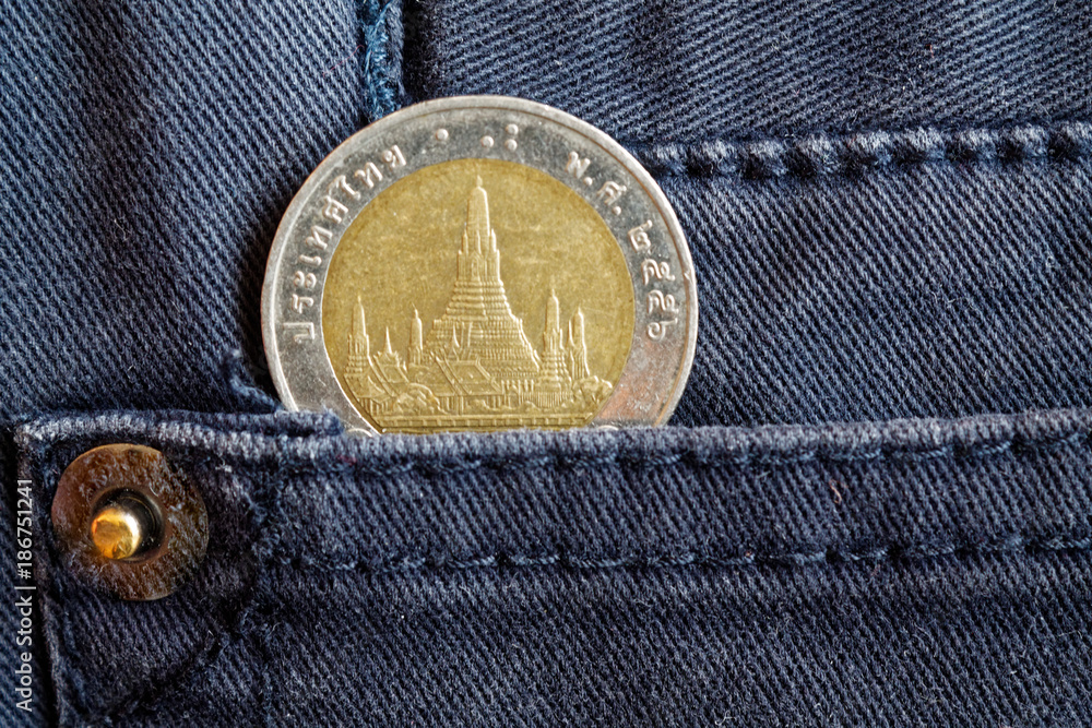 Thai coin with a denomination of 10 baht in the pocket of gray denim jeans Thai coin with a denomination of 10 baht in the pocket of gray denim jeans