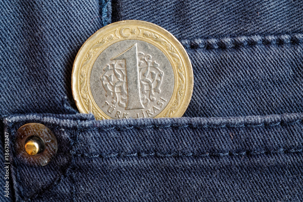 Turkish coin with a denomination of 1 lira in the pocket of gray denim jeans Turkish coin with a denomination of 1 lira in the pocket of gray denim jeans