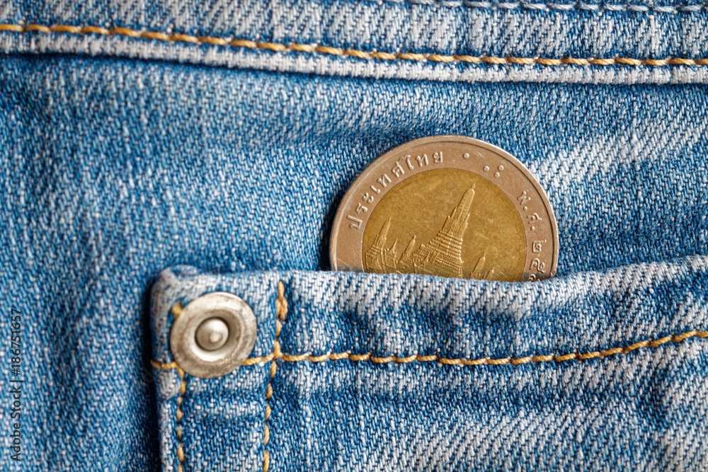 Thai coin with a denomination of 10 baht in the pocket of light blue denim jeans Thai coin with a denomination of 10 baht in the pocket of light blue denim jeans