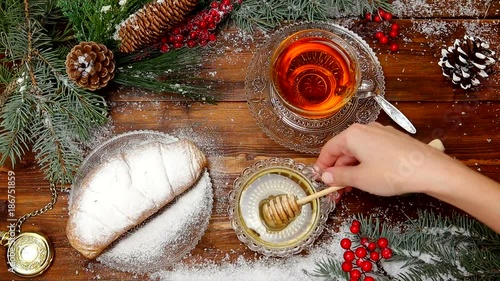 winter tea A cup of tea with honey and croissant or cookies, a branch of a Christmas tree in the snow, Christmas lights