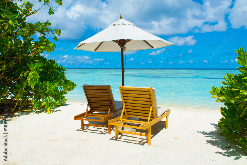 Beautiful landscape with sunbeds and umbrellas on the sandy beach, Maldives island