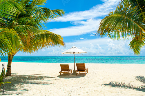 Fototapeta Naklejka Na Ścianę i Meble -  Beautiful landscape with sunbeds and umbrellas on the sandy beach, Maldives island