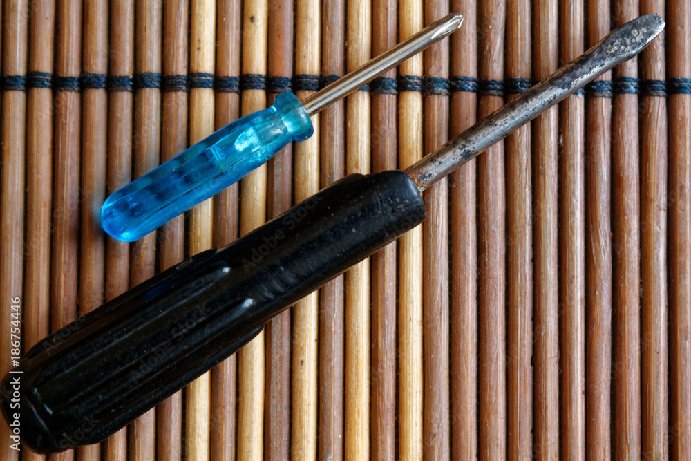 Screws and screwdriver on wooden background Screws and screwdriver on wooden background