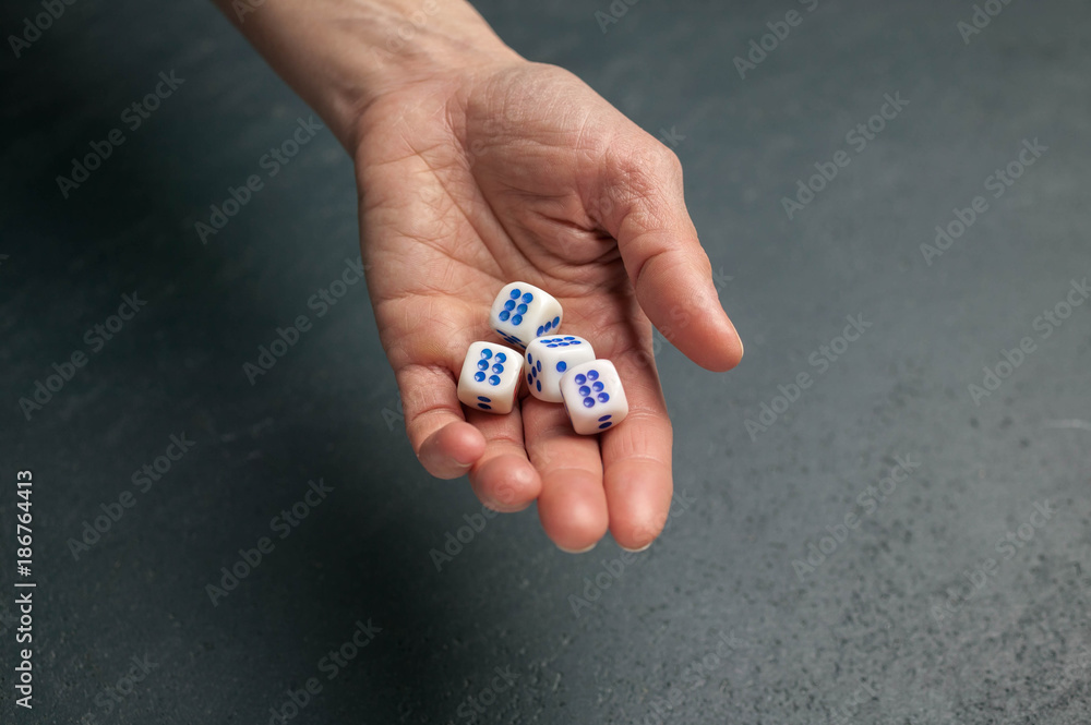 Dice. The female hand holds dice. Dark background Dice. The female hand holds dice. Dark background