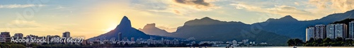 Panoramic image of the first summer sunset of the year 2018 seen from the lagoon Rodrigo de Freitas with the buildings of the city of Rio de Janeiro  hill Dois Irm    os and Gavea stone
