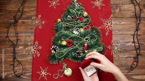 a small Christmas tree of tinsel, nuts, ribbons and ornaments. Gift for a Christmas tree, a vintage watch. 2018,