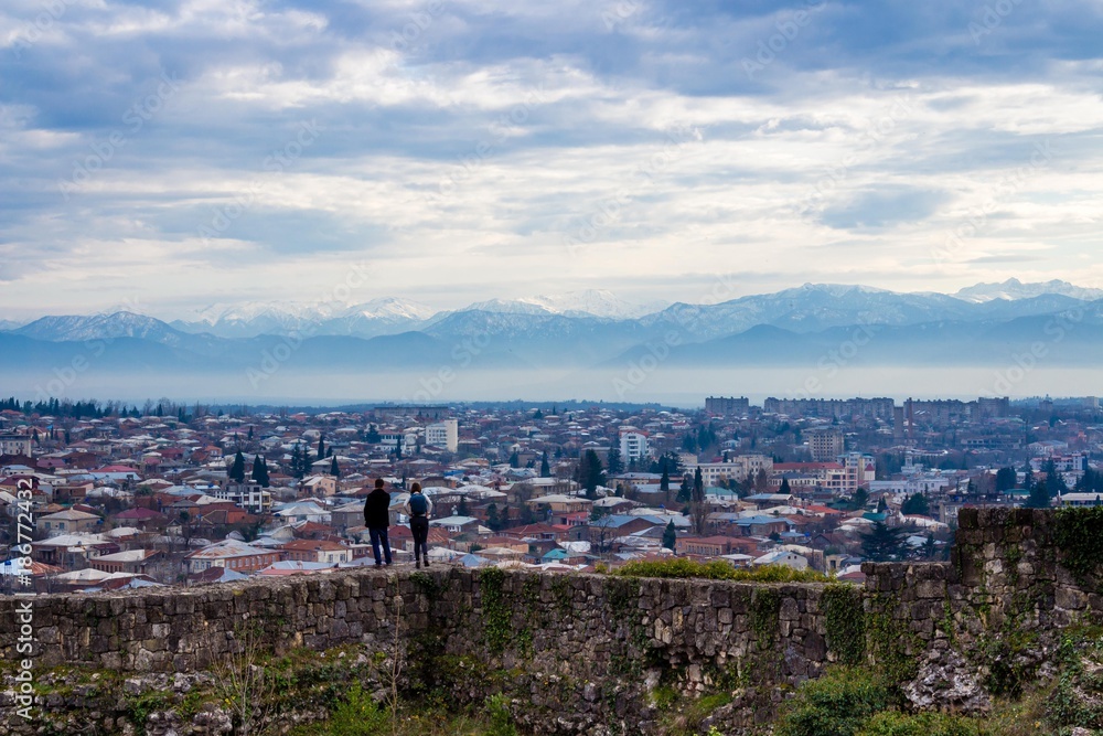 Couple look out over the city towards the mountains