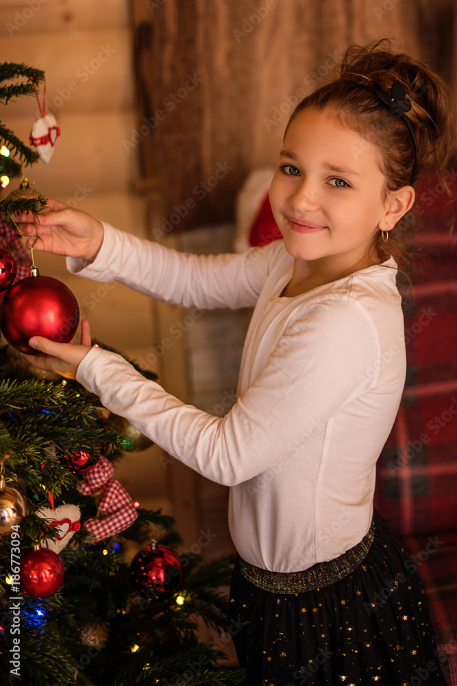 young girl deccorating christmas tree 