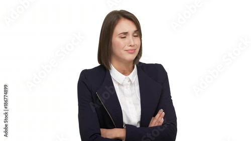 portrait of sarcastic young businesswoman wearing white blouse and black jacket standing with arms folded distrust disbelieve in what she hearing over white background. Concept of emotions