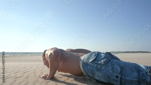 Man doing workout at the beach with sunshine background