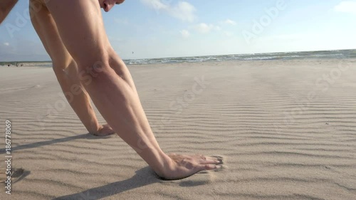 Shirtless man doing pull ups at the beach close up