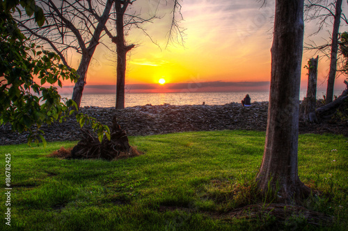 Sunset over Lake Erie on Kelley's Island with green grass and orange sky photo