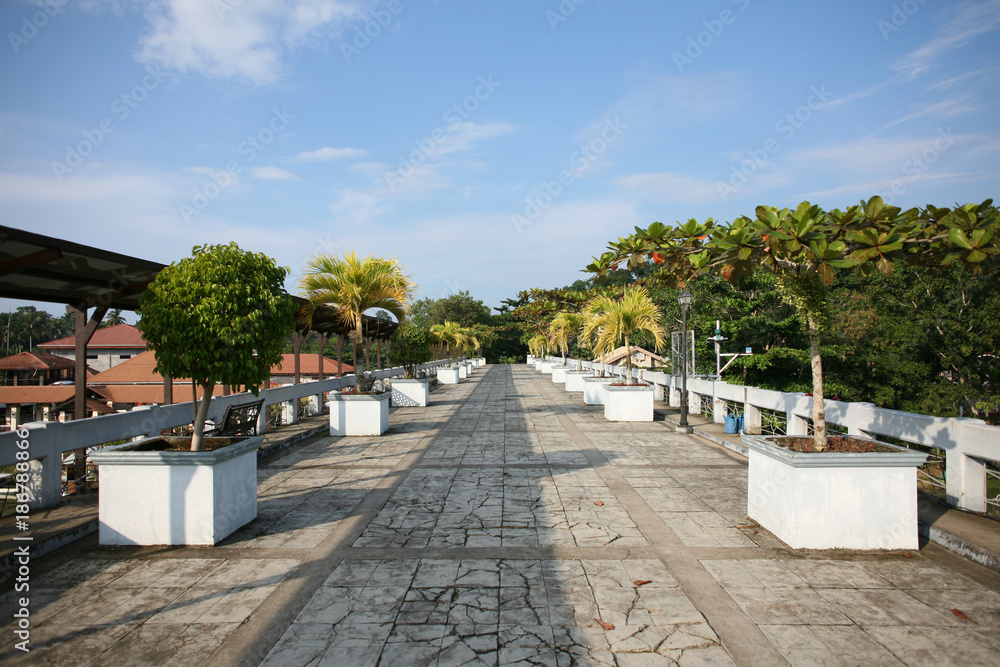 Evening shadows on a bridge over Loboc river lined with palm trees, in Loboc, Bohol, the Philippines Evening shadows on a bridge over Loboc river lined with palm trees, in Loboc, Bohol, the Philippines