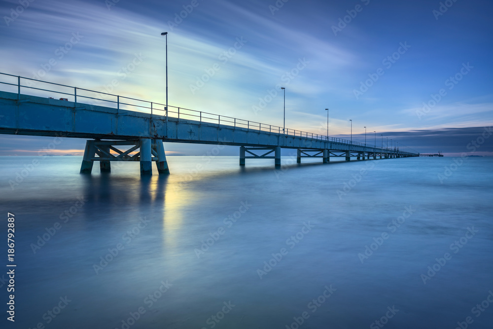 Industrial pier on the sea. Side view. Long exposure photography.