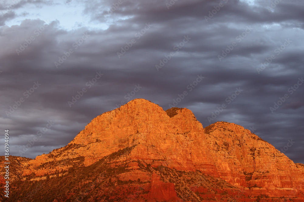 Fototapeta premium Last light near Sedona, Arizona. Beautiful cloud sky and illuminated red rock formation.