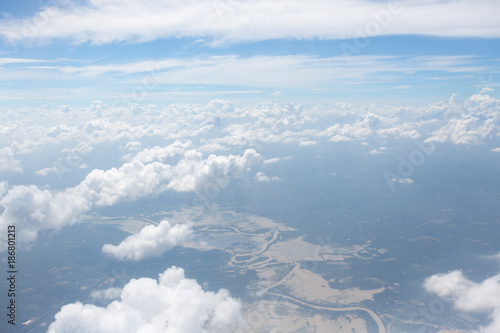 Fotografie Aerial view on clouds and blue sky from airplane window