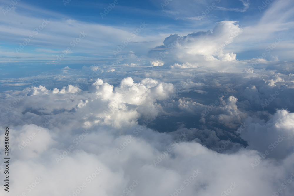Aerial view on clouds and blue sky from airplane window Aerial view on clouds and blue sky from airplane window