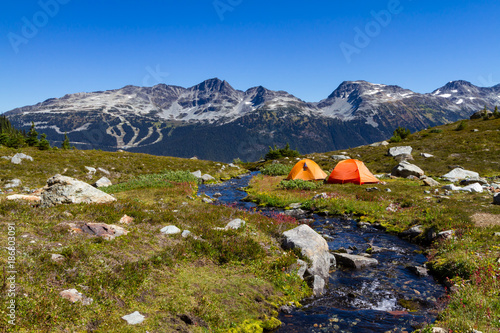 Summer is here which means it's camping season around the corner.  Scenic landscape of mountains and tents