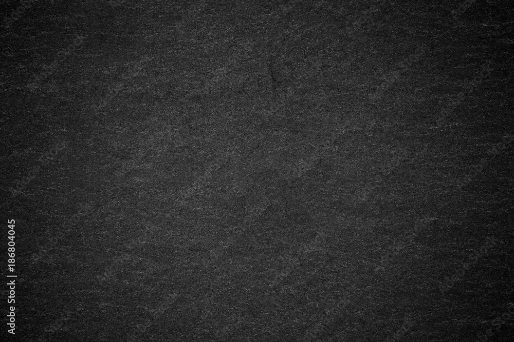 Dark grey black slate background or natural stone texture.