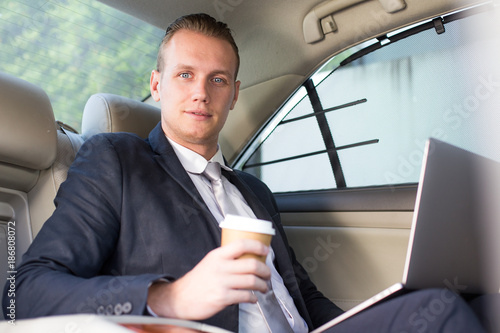 Business man using Laptop for working in car with attractive smiling, Man working concept. © Bavorndej