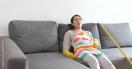 Housewife sitting on sofa after doing all housework