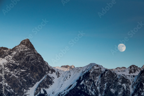 full moon rising over winter landscape in the Swiss Alps near Maienfeld