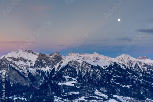 full moon rising over winter landscape in the Swiss Alps near Maienfeld